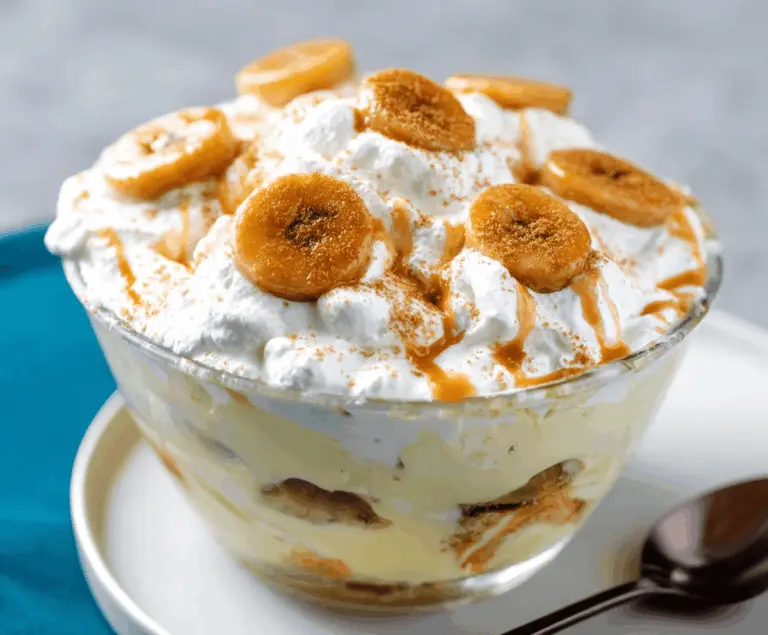 Delicious Banana's Foster Banana Pudding topped with caramelized bananas and whipped cream, perfect for a sweet dessert treat.
