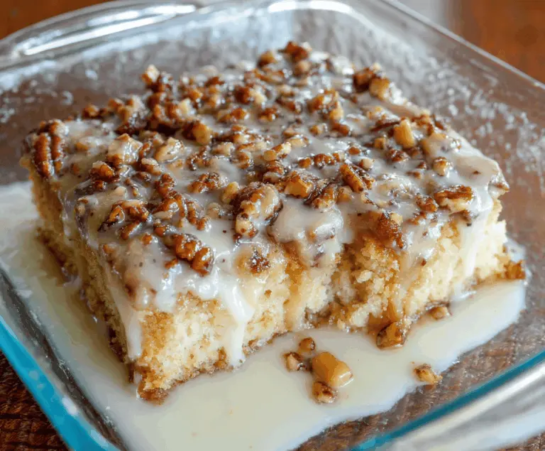Delicious Butter Pecan Praline Poke Cake topped with whipped cream and chopped pecans, featuring a rich caramel and pecan topping