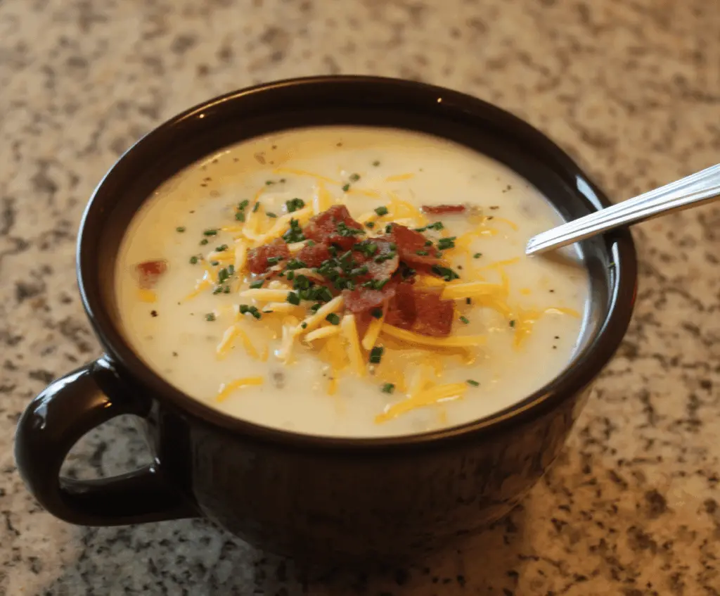 Creamy Outback Steakhouse Potato Soup served in a bowl with chopped green onions and crispy bacon on top, perfect for a hearty appetizer or meal.