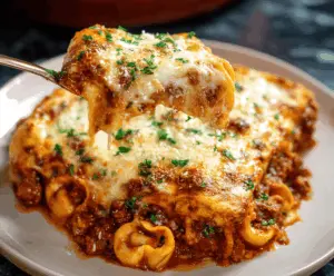Delicious baked tortellini lasagna served in a baking dish with melted cheese and fresh herbs.
