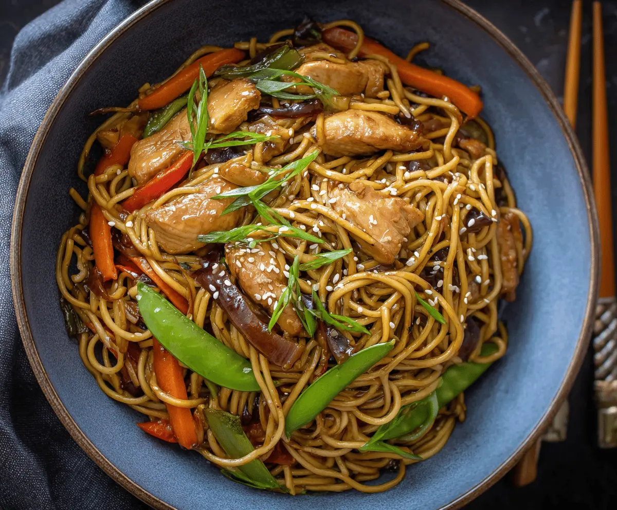 Delicious Chicken Teriyaki Noodles garnished with sesame seeds and green onions on a plate