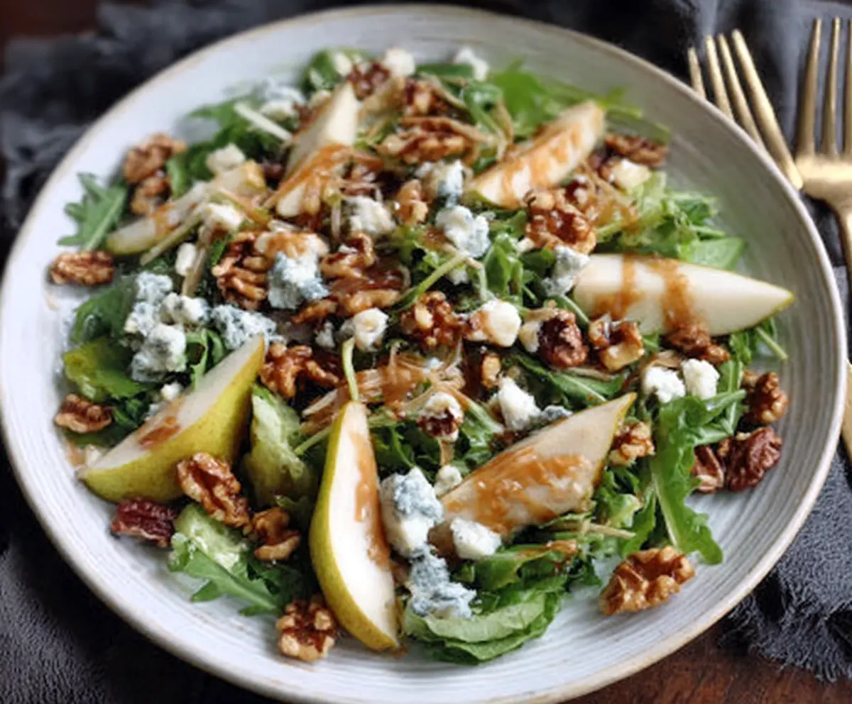 Fresh Pear and Gorgonzola Salad topped with Candied Walnuts on a plate.