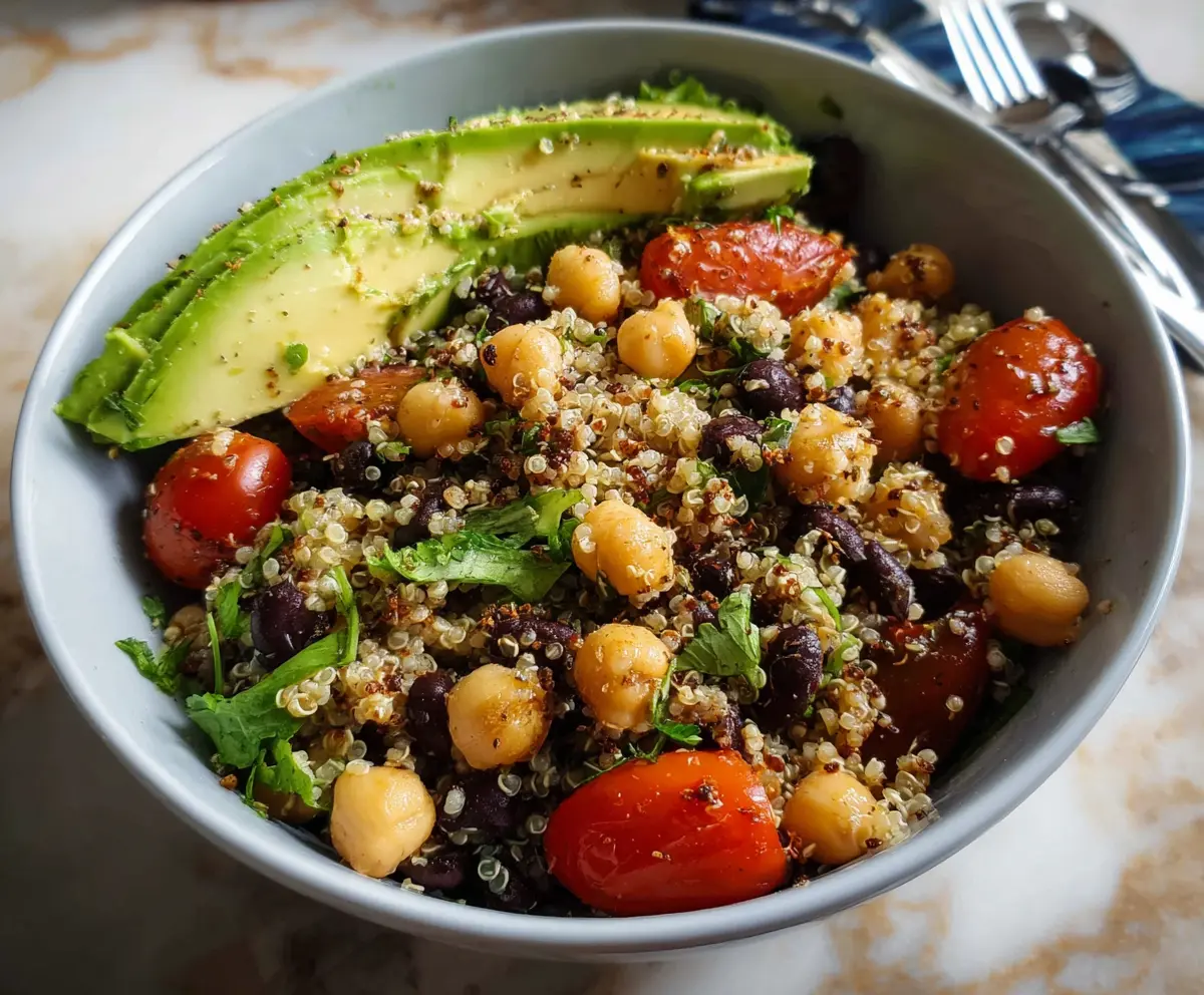Healthy quinoa bowl topped with fresh avocado slices and seasoned chickpeas, perfect for a nutritious meal.