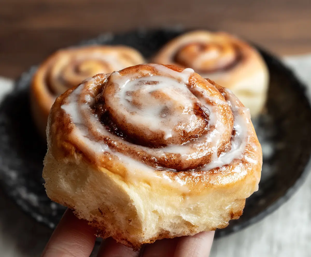 Delicious homemade sourdough discard cinnamon rolls fresh out of the oven, topped with icing.