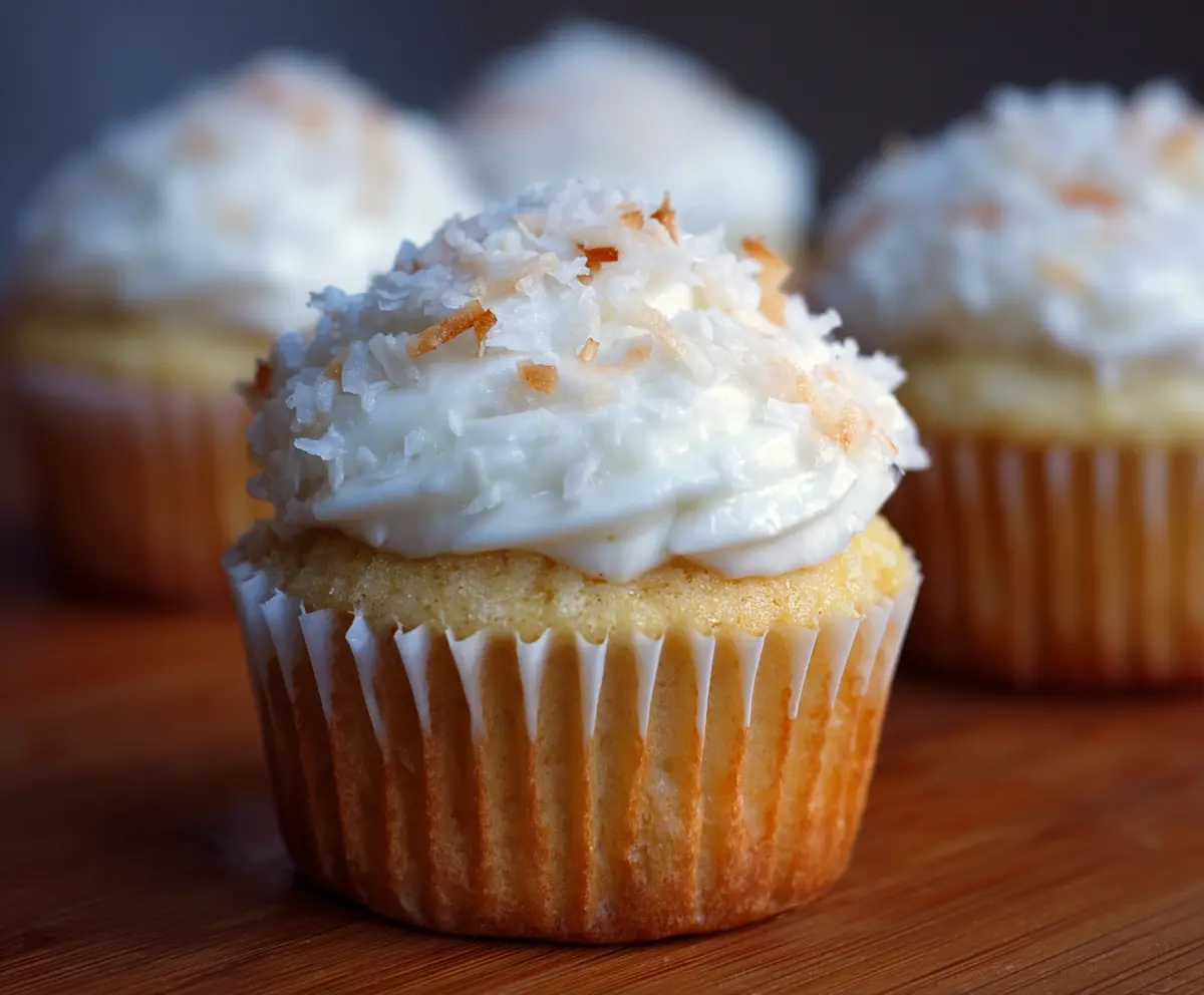 Delicious coconut cupcakes topped with shredded coconut and frosting
