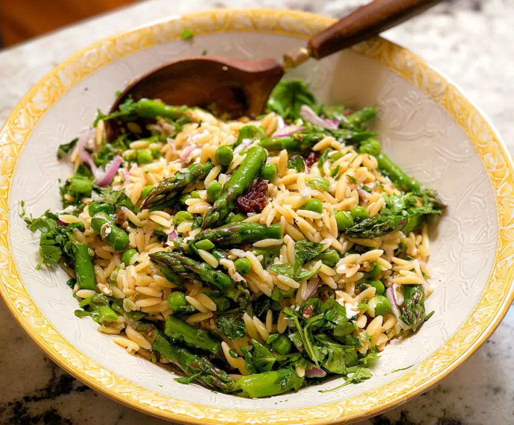 Fresh orzo salad with tender asparagus and colorful vegetables, perfect for a light, healthy meal.